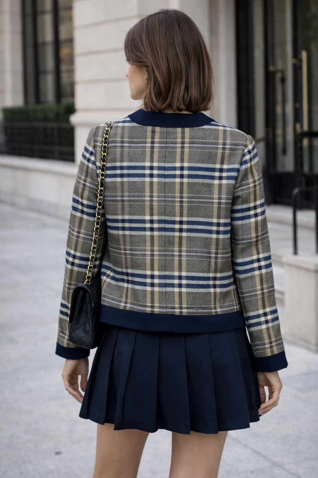 Jaqueta curta em tweed xadrez com acabamento contrastante