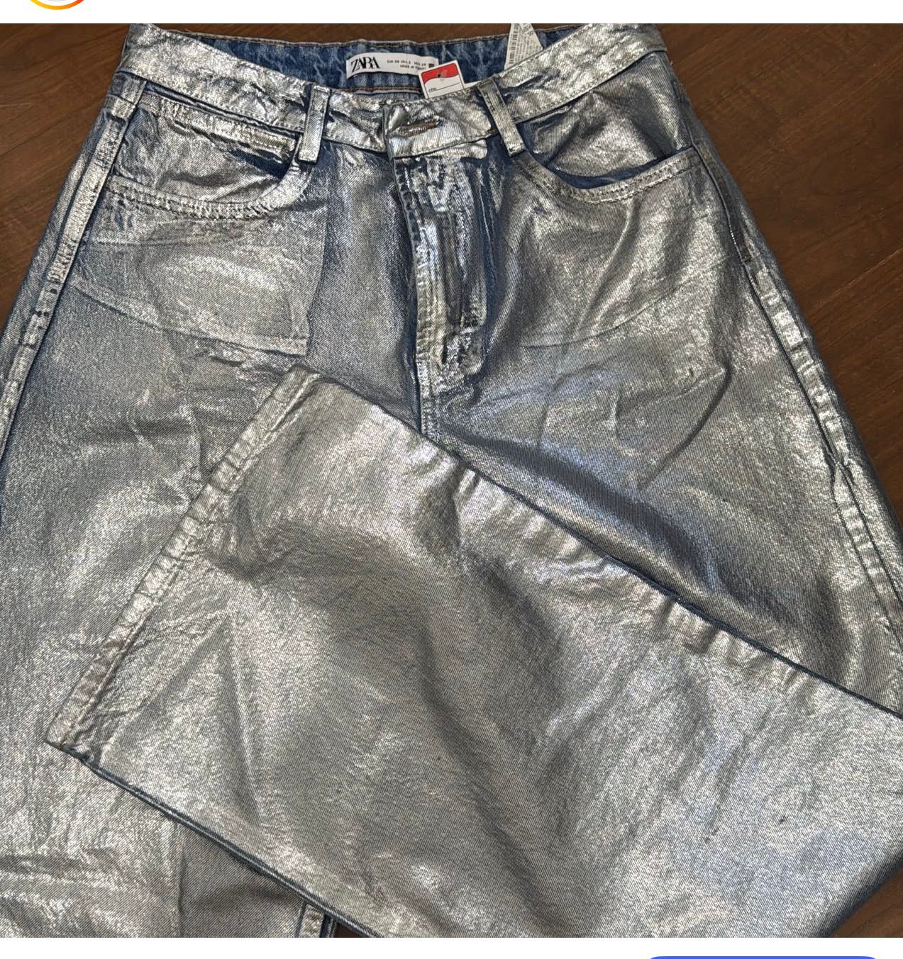 Calça pantalona metalizada com brilho e modelagem ampla.